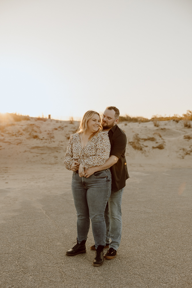 couple stands close together and cuddles in.