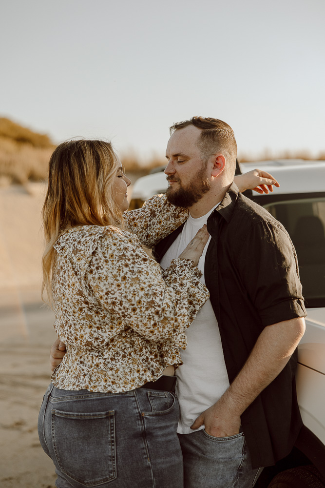 Couple stands close and stares into each others eyes.