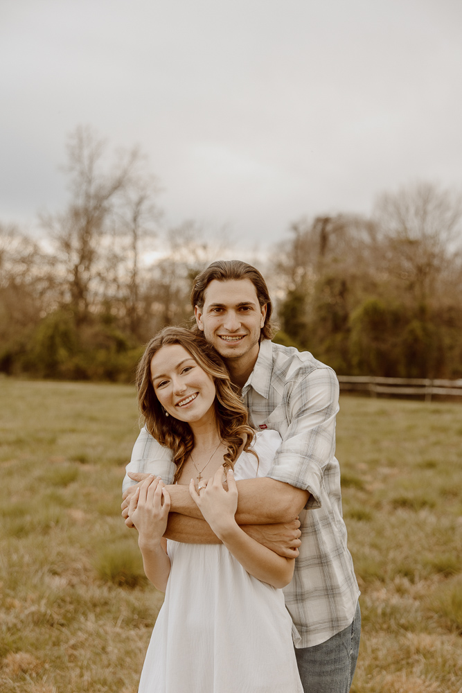 Couple wrapping their arms around each other and smiling.