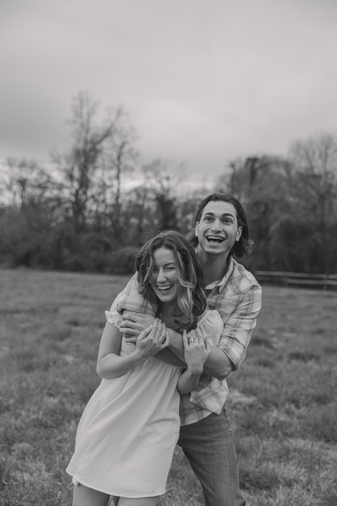 Couple laughing while hugging in their engagement photos.