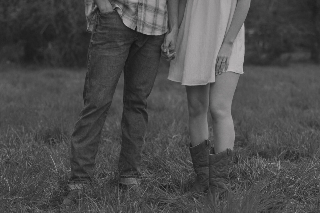 Couple holding hands while showing off their cowboy boots.