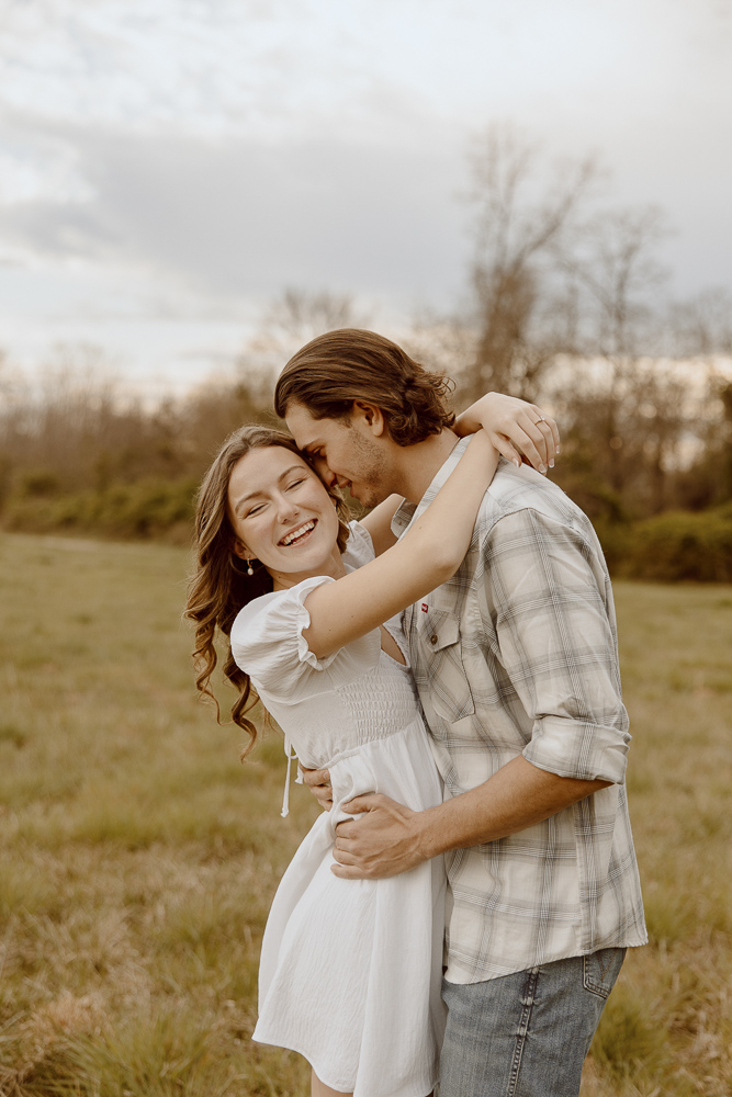 Couple with arms wrapped around each other while smiling.