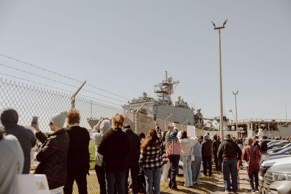 A Navy ship pulling into its home port for homecoming.