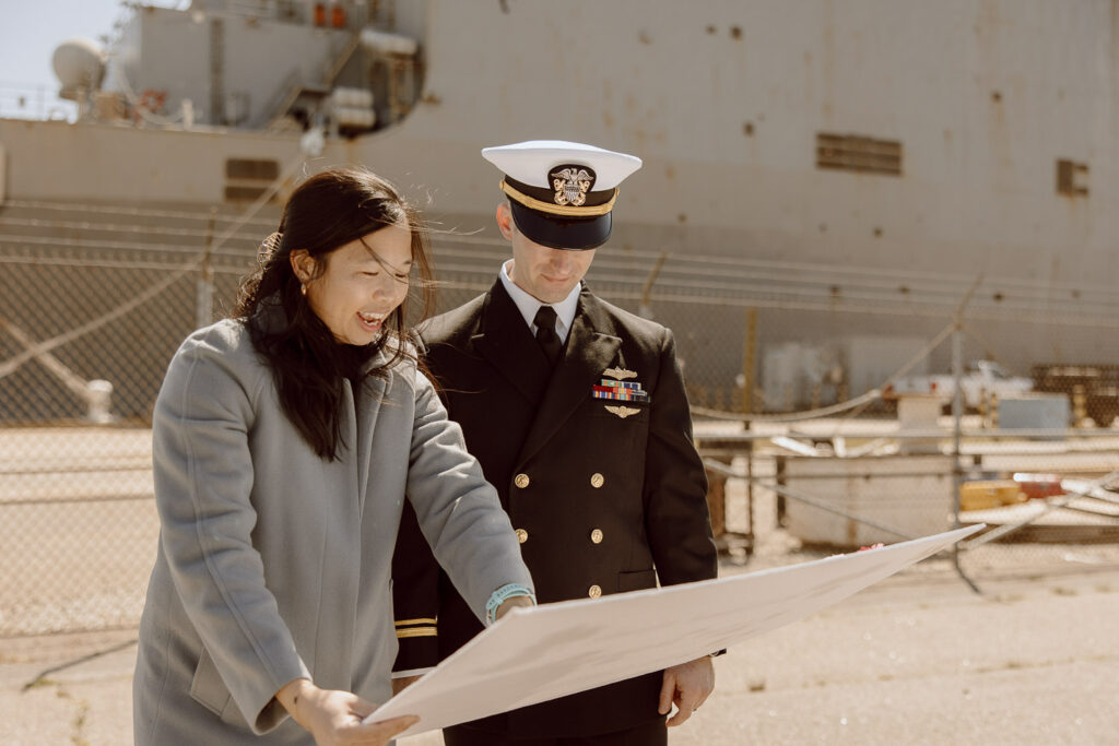 A navy spouse showing her husband the welcome home sign she made for him.