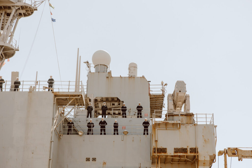 Navy sailors stand in structure as they are welcomed home from deployment.