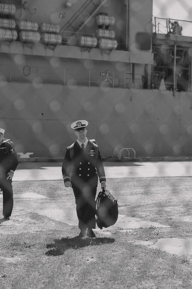 Navy sailor walks towards his wife after disembarking the ship.