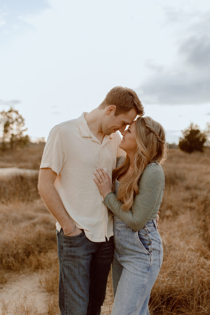 This image is of a couple standing next two each other with their foreheads and noses touching.