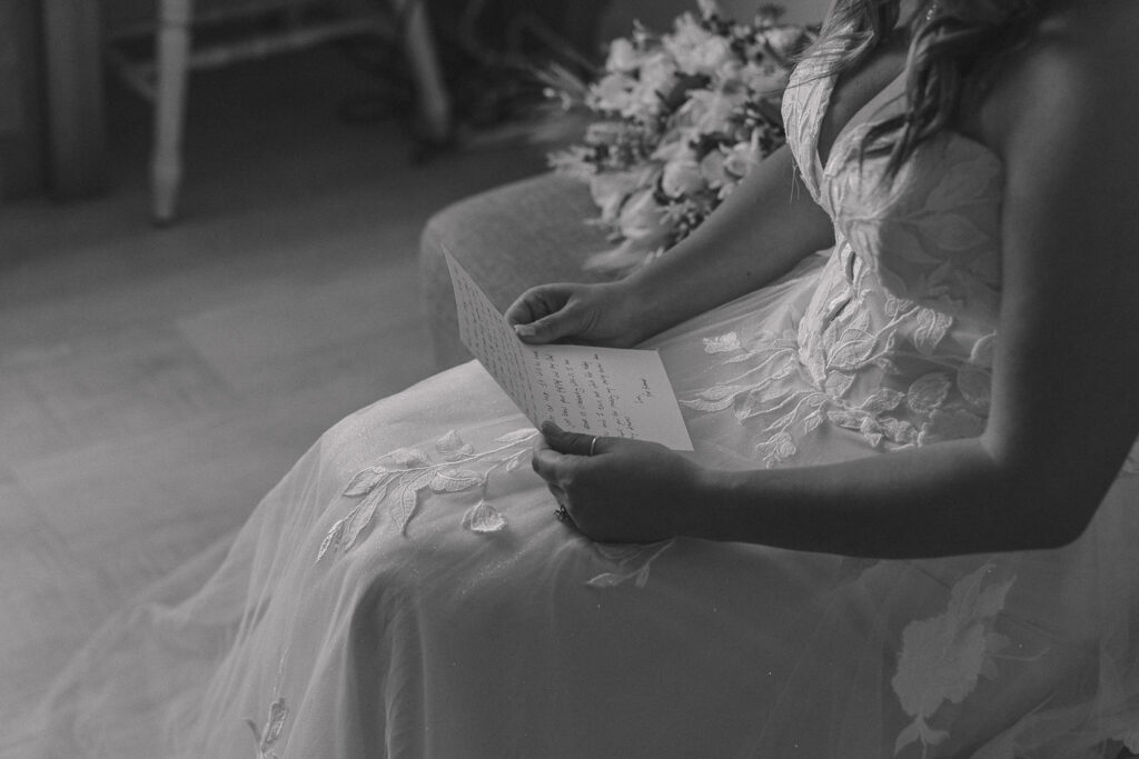 A bride holds and reads a handwritten letter from her groom.