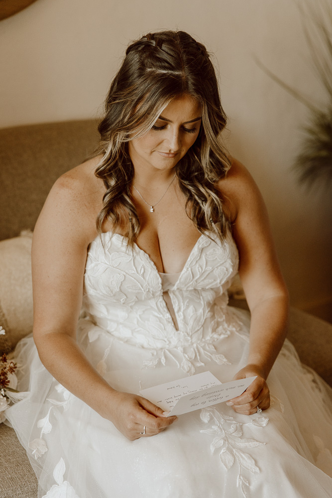 A smile reads a handwritten letter from her groom before the wedding ceremony.