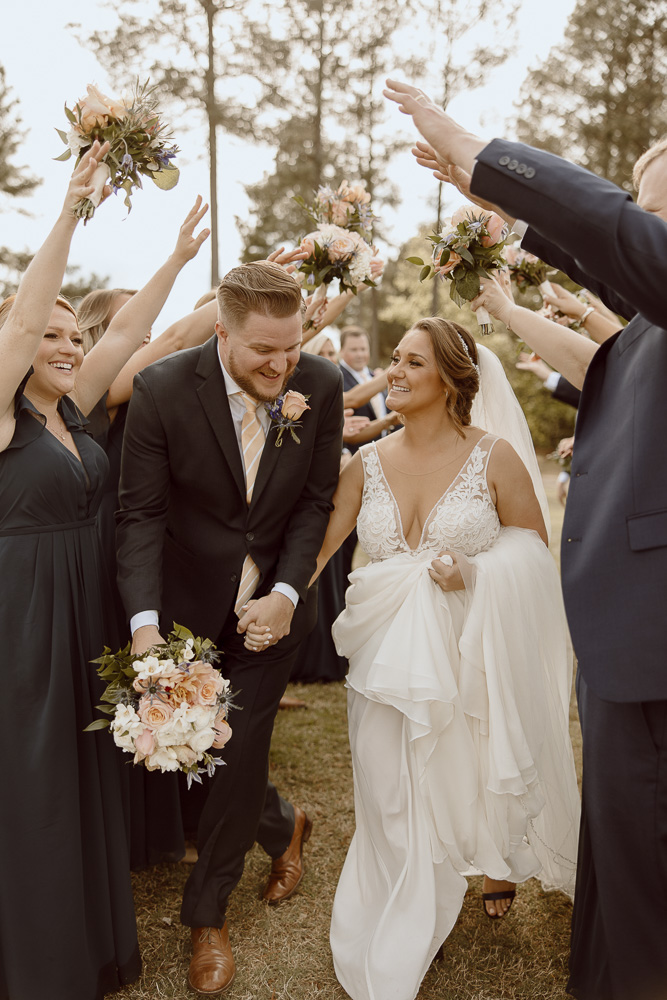 Wedding Party and Bridal Party Poses, Couple runs through a tunnel of bridesmaids and groomsmen.